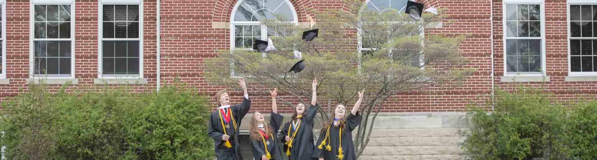 牛津大学的学生们戴着毕业礼扔着他们的帽子.