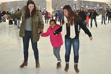 Students ice skating with young lady